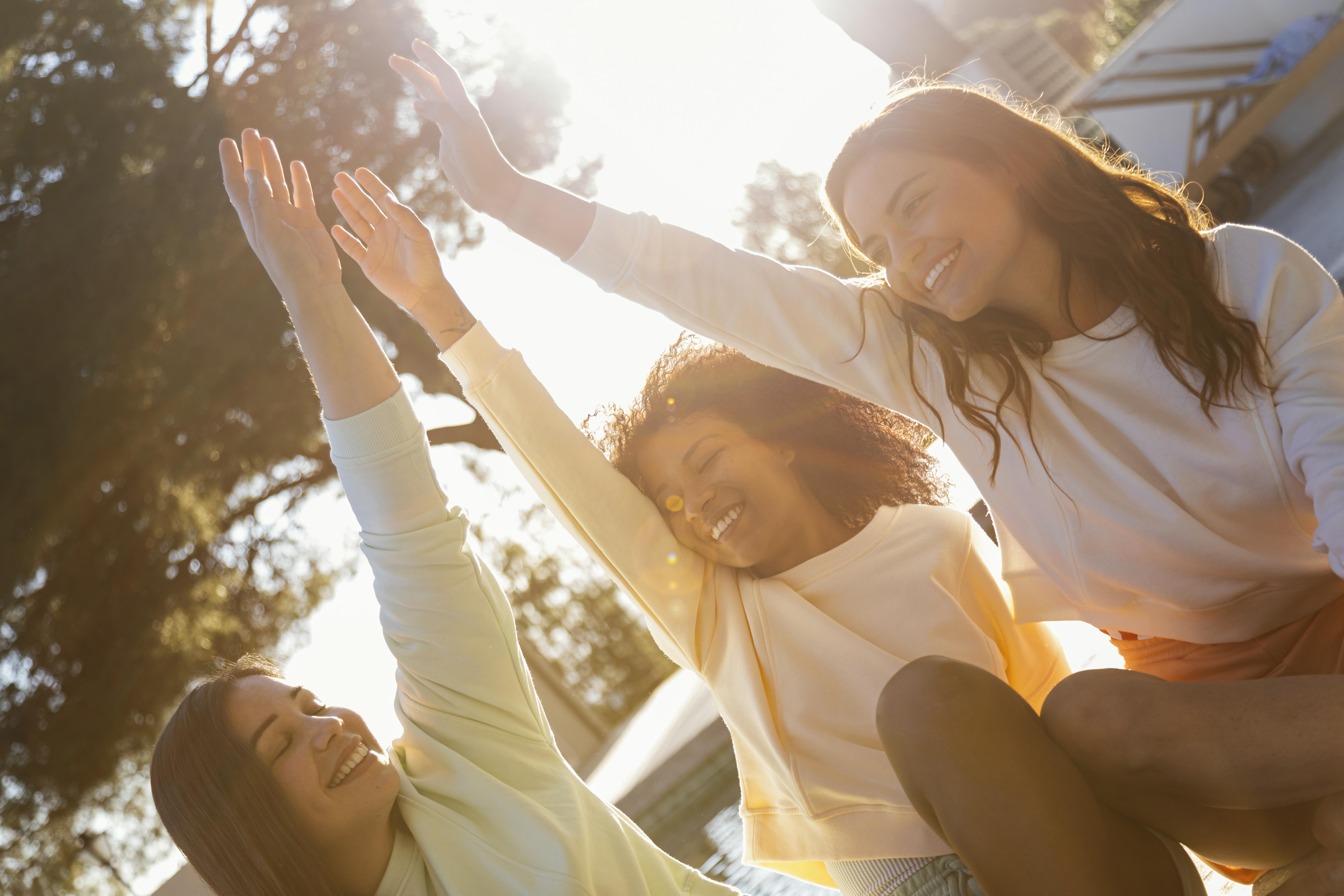 Grupo de pessoas sorrindo ao ar livre, representando bem-estar e saúde emocional